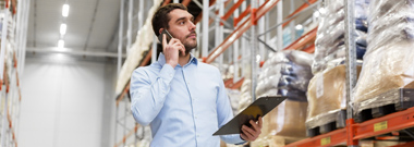 Businessman calling on smartphone at warehouse