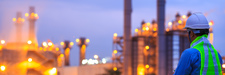 Worker at refinery unit at night