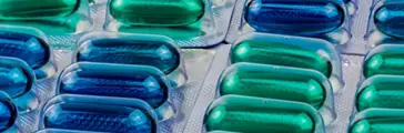 Blue and green soft gel capsule pills in blister pack