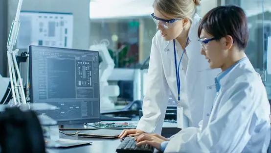 Two scientists working with software on desktop computer