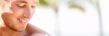 Man applying bio-derived and biodegradable sunblock to shoulder