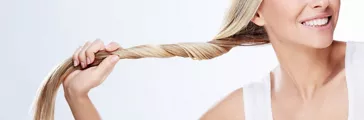 Schöne junge Frau hält Haare