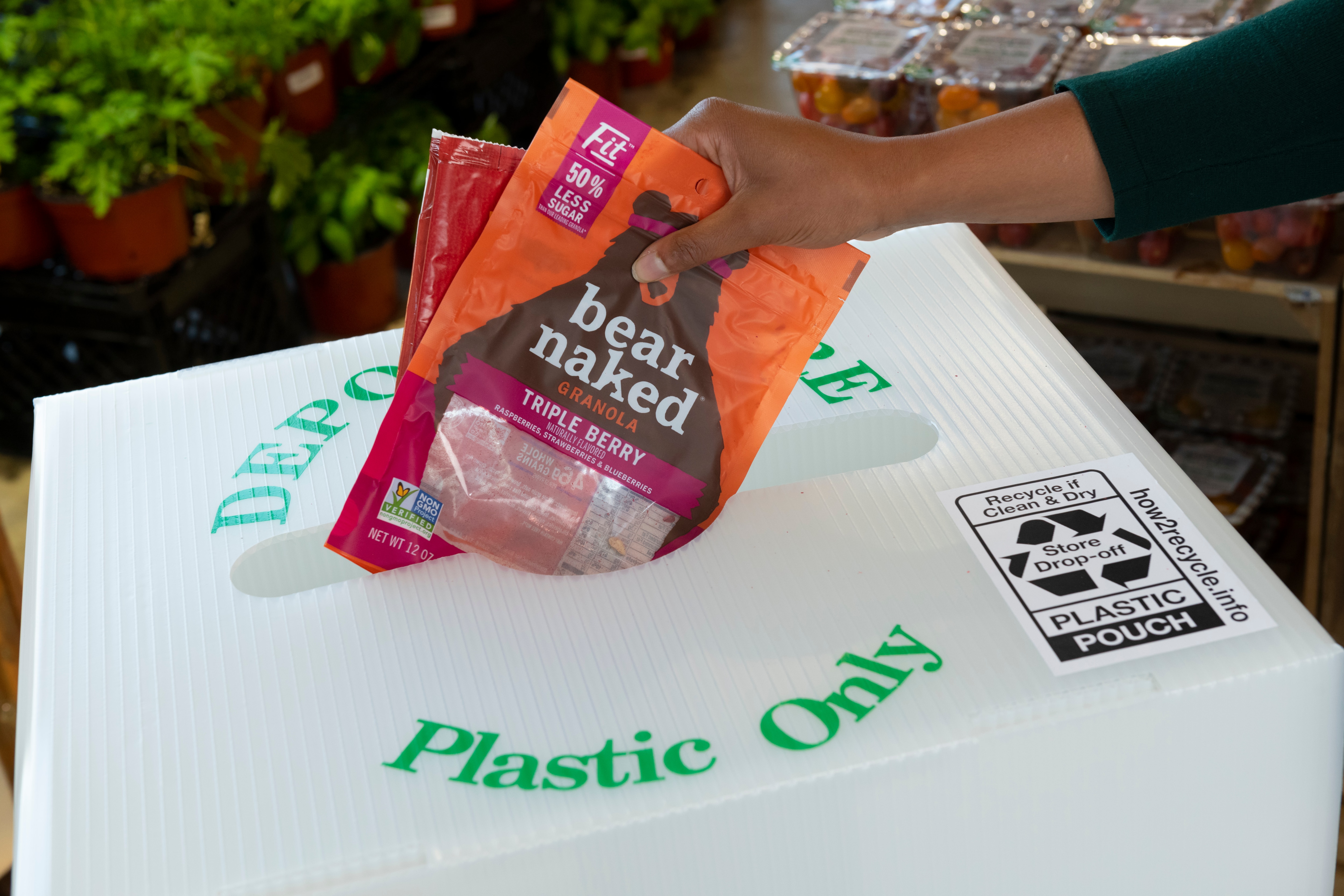 bear naked plastic packaging being placed in a Plastic Only recycle bin at the grocery store.